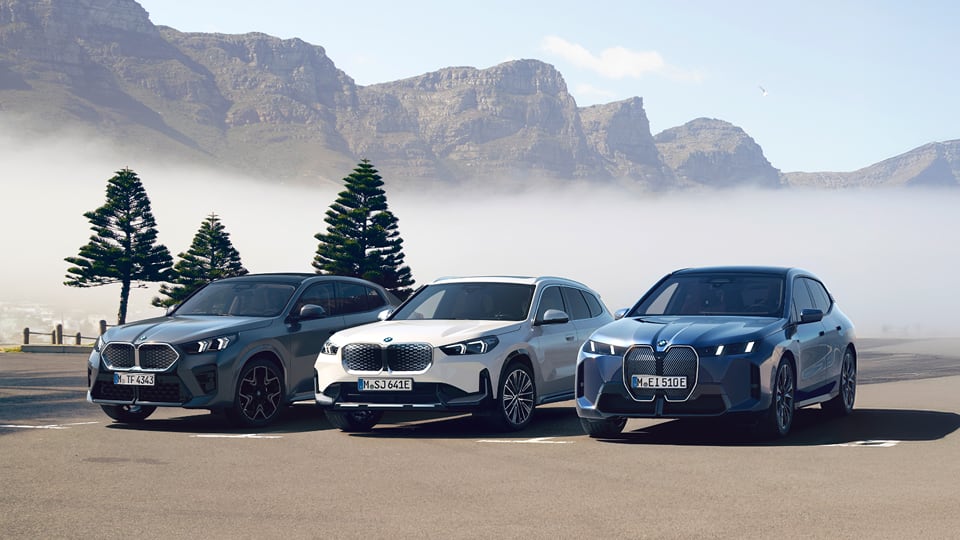 Front angled view of multiple BMW vehicles with mountain background