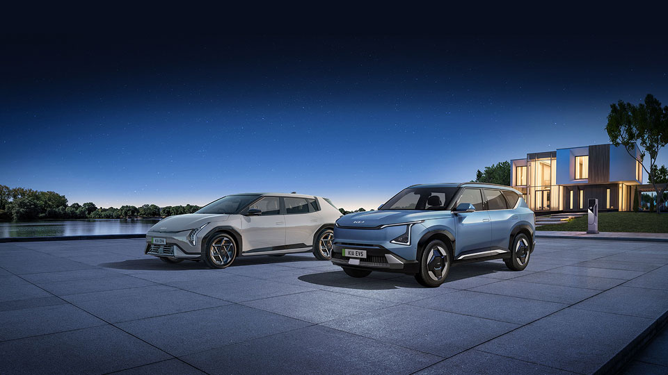 Front angled view of Kia EV4 and EV5 parked outside at night