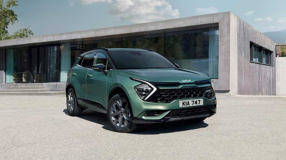 Front angled view of the Kia Sportage outside a modern home