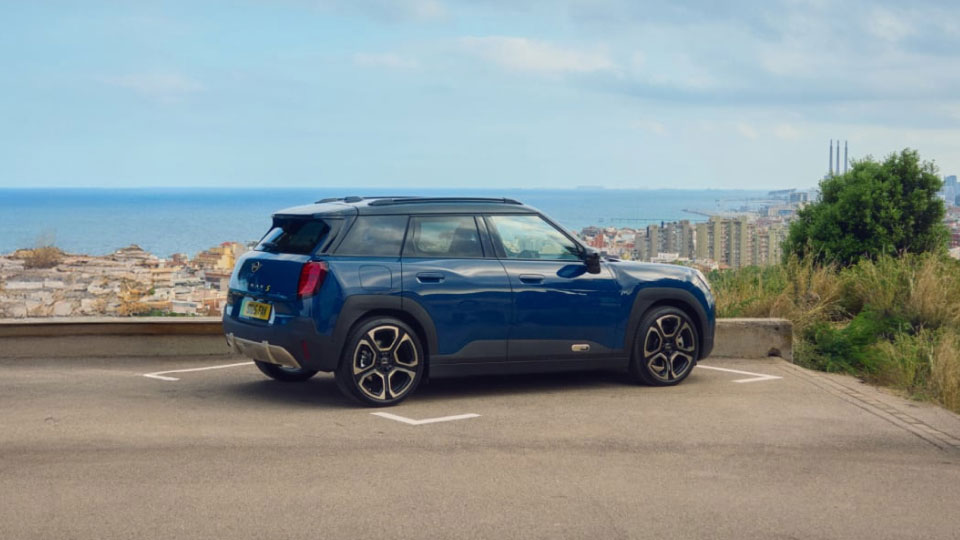 Rear side angled view of MINI Aceman in navy blue