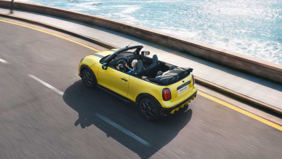 MINI Copper Convertible in light green driving along seafront road