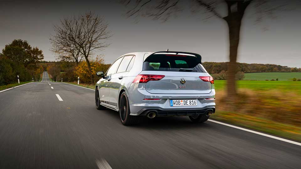 Silver Volkswagen Golf GTI 50 driving down a country road