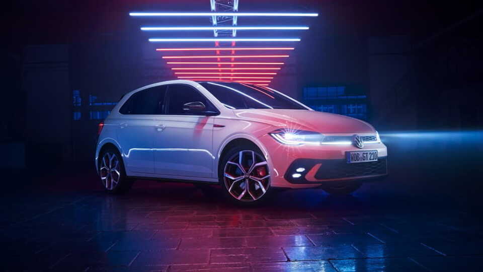 White Volkswagen Polo in a dark warehouse with neon lights