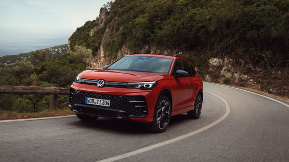 Volkswagen Tigan in red, driving through mountain roads